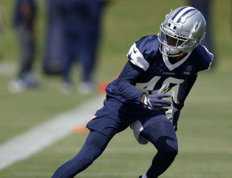 Nahshon Wright, in a blue and white uniform, practices diligently on the football field.