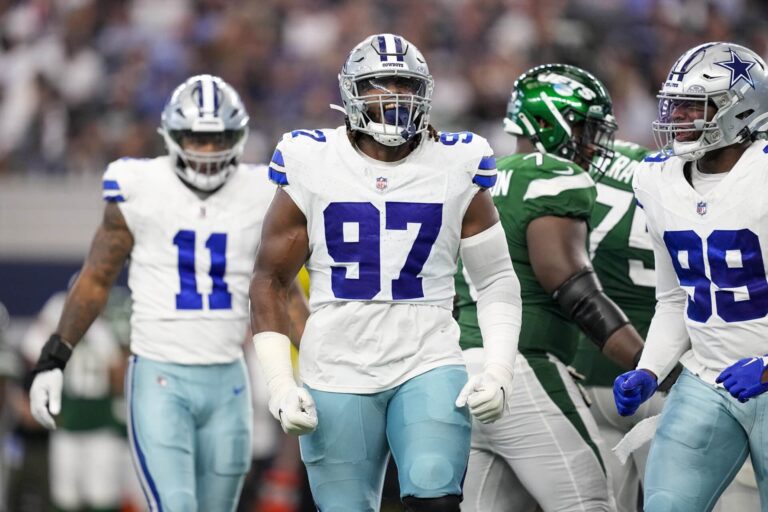 Football players from the Cowboys and Jets during a game, with a focus on a Cowboy wearing jersey number 97.