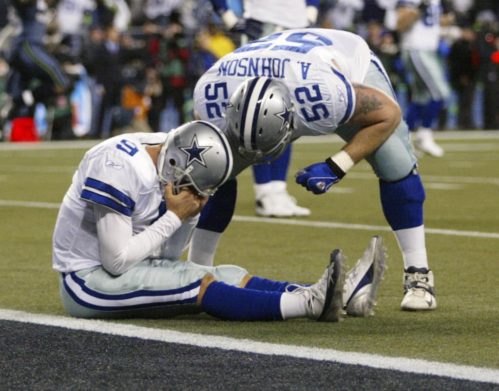 ORG XMIT: *S0418823696* Dallas Cowboys quarterback Tony Romo holds his head as Al Johnson leans over him after the botched field goal play with 1:19 left in the 21-20 loss to the Seattle Seahawks'in an NFC wild card playoff football in Seattle, Saturday, Jan. 6, 2007. (AP Photo/John Froschauer) SEA125 01072007xSPORTS 01082007xQUICK 01082007xALDIA 09062007xProFootball2007 09072007xQUICK 12312007xQUICK 11272008xALDIA