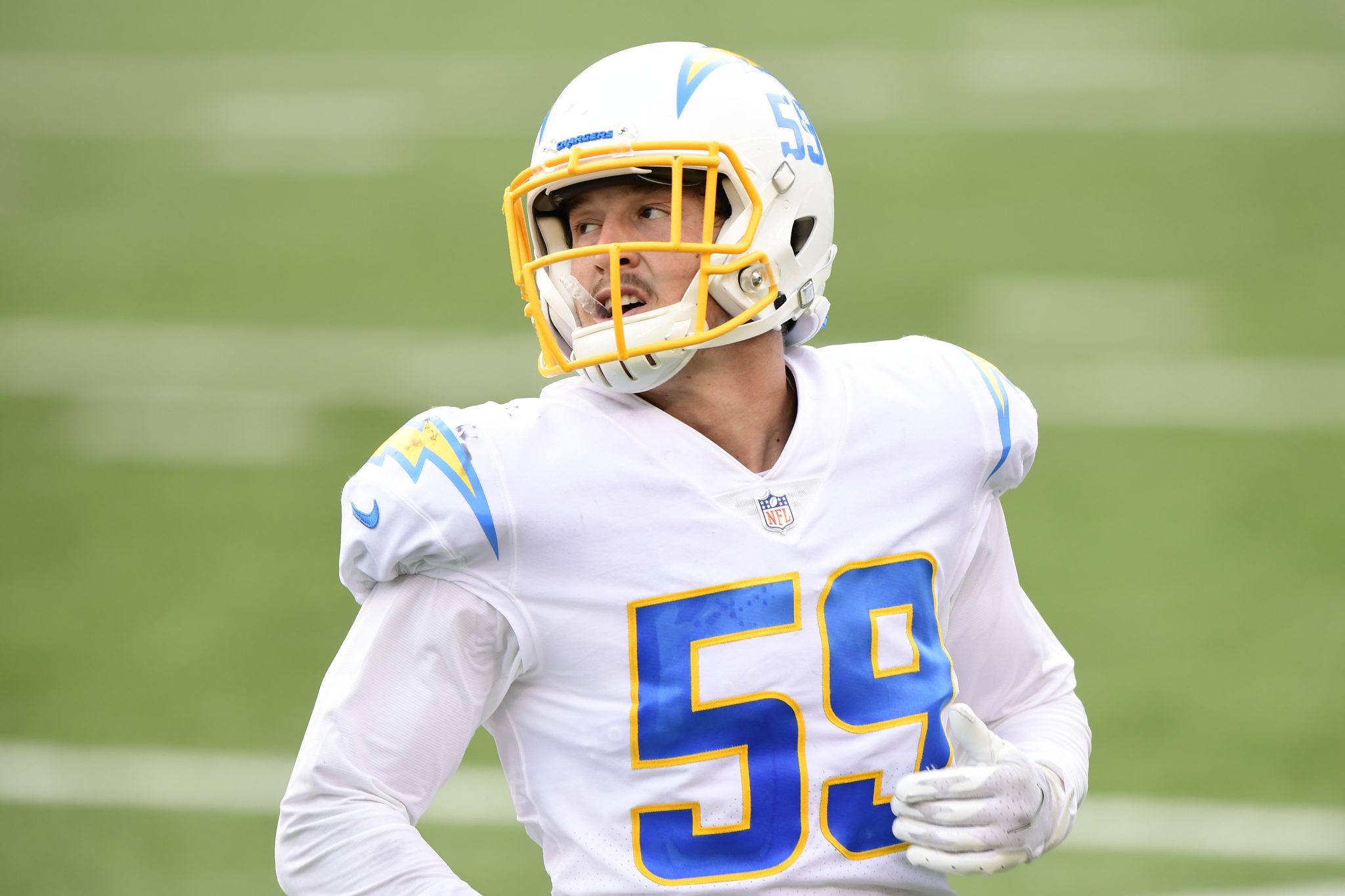 Football player wearing a white and yellow uniform with number 59 on the field.