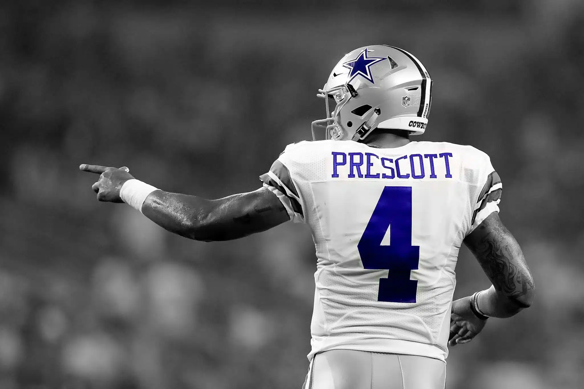 Football player in a white uniform and helmet pointing, with "Prescott" and number "4" visible on his back.