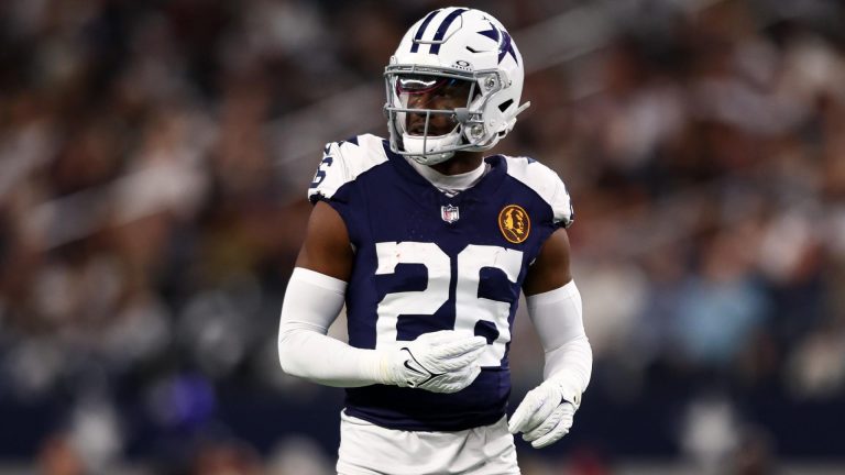 Football player in a Dallas Cowboys uniform and helmet on the field during a game.