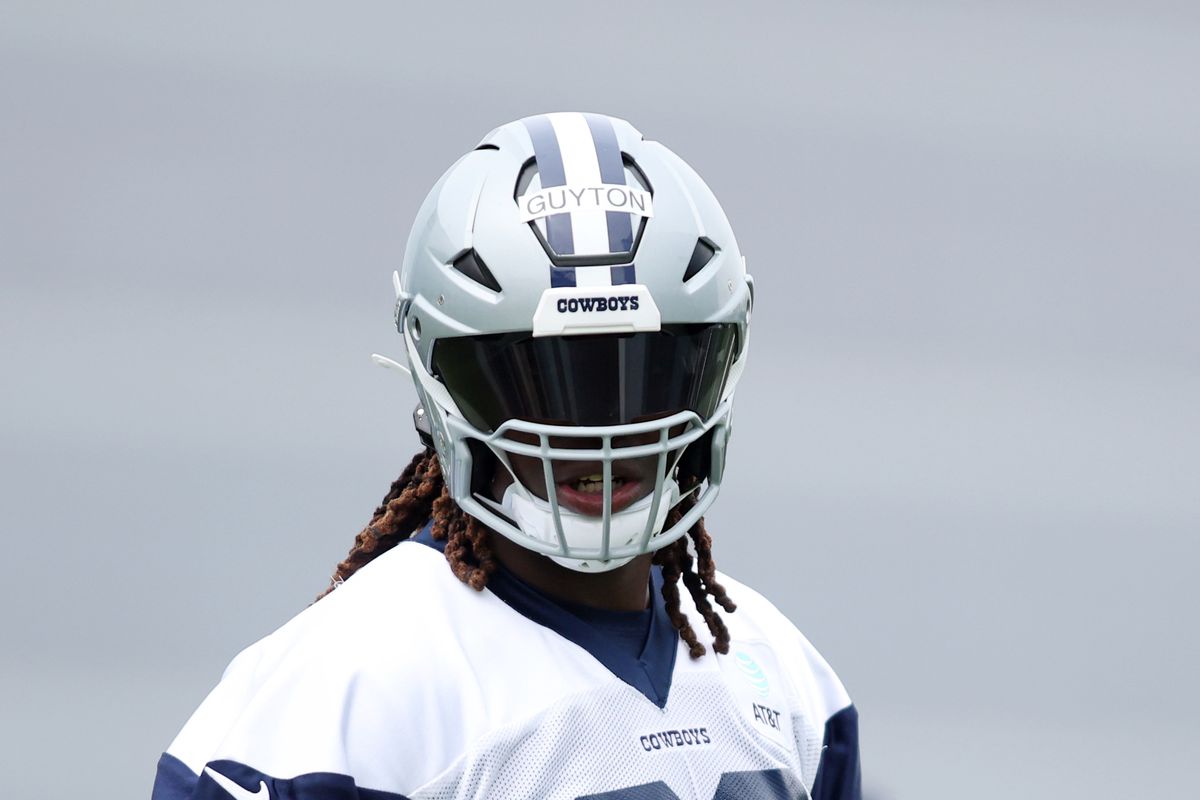 A football player in a Cowboys helmet with a tinted visor and a jersey labeled "GUYTON.