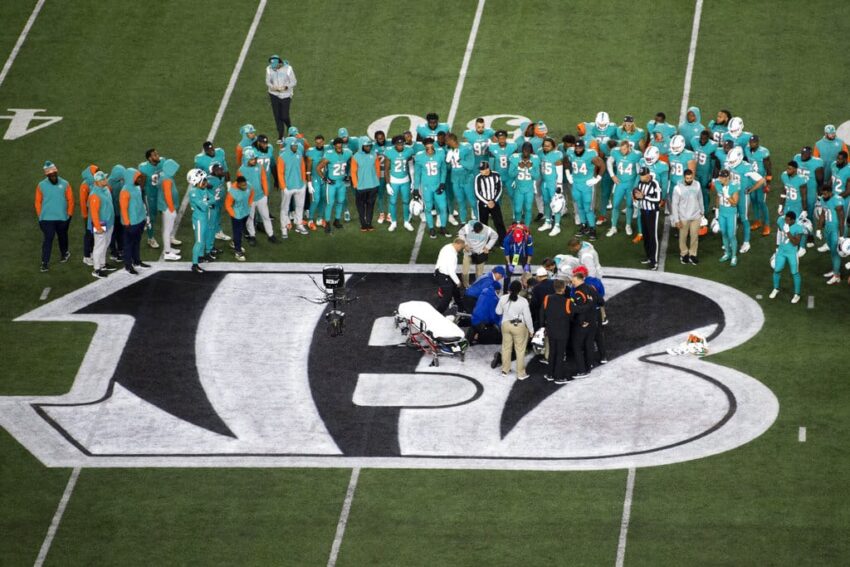 Teammates gather around Miami Dolphins quarterback Tua Tagovailoa (1) after an injury during the first half of an NFL football game against the Cincinnati Bengals, Thursday, Sept. 29, 2022, in Cincinnati. (AP Photo/Emilee Chinn)